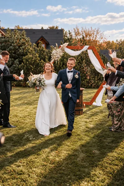 Odchod novomanželů mezi hosty po obřadu