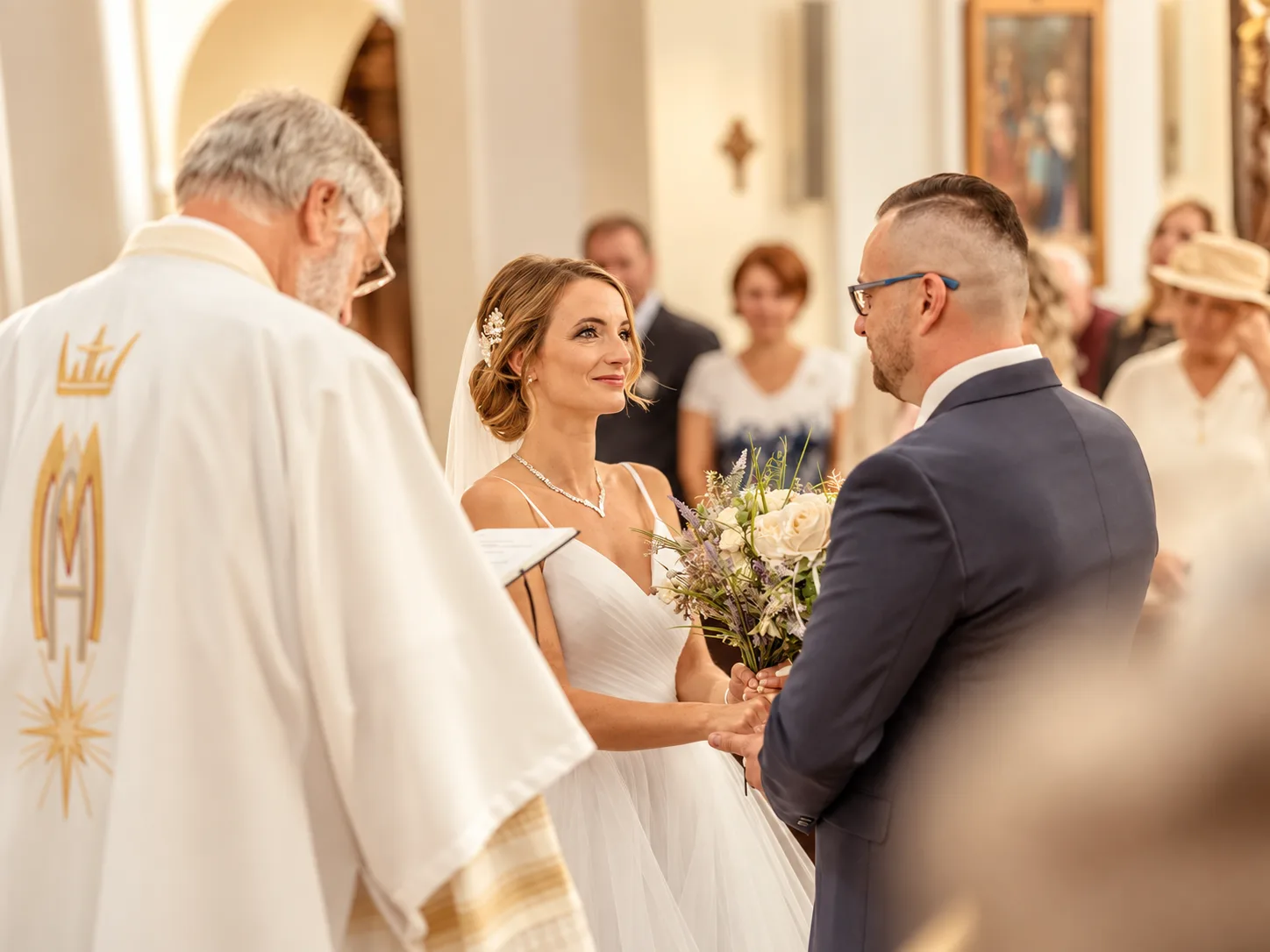 Nevěsta a ženich před oltářem při církevním obřadu